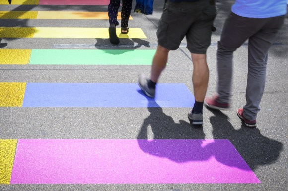 Foto di un attraversamento pedonale arcobaleno con persone che camminano