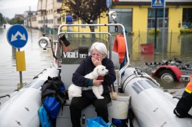 Una donna anziana e il suo cagnolino soccorsi con il gommone dei vigili del fuoco.