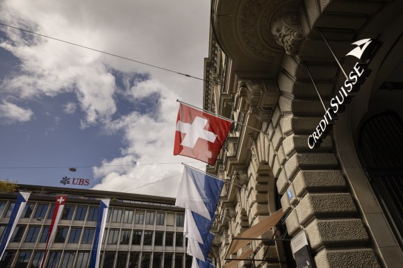 bandiera svizzera davanti a un edificio con il logo credit suisse