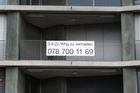 balcone di un appartamento con cartellone da affittare