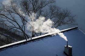 fumo esce da canan fumaria su tetto innevato