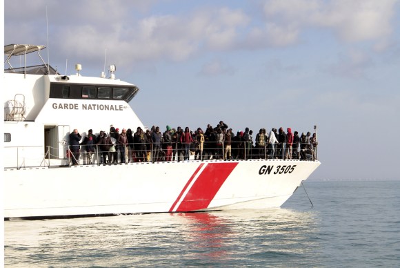 Migranti su una barca della guardia costiera