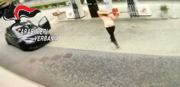 uomo a petto nudo brandisce un fucile. immagine da videocamera di sicurezza