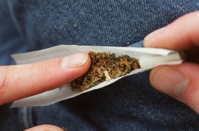 Primo piano di una sigaretta che contiene foglie di cannabis.