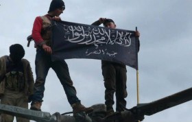 due uomini tengono uno striscione di al nusra