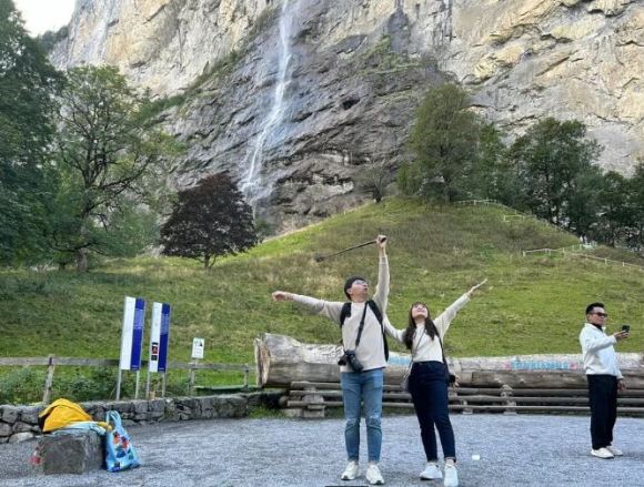 Turisti asiatici in posa davanti alla cascata
