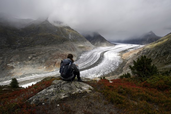Person sitting above the Aletsch glacier in Switzerland