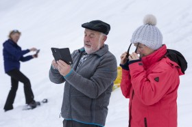 due persone anziane osservano uno smartphone tenuto dall uomo