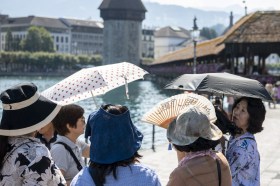 turiste con ombrellini davanti a un ponte