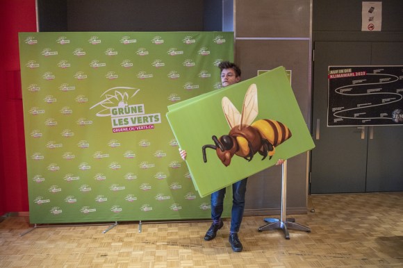 Persona con cartellone rappresentante un ape daventi a manifesto dei Verdi