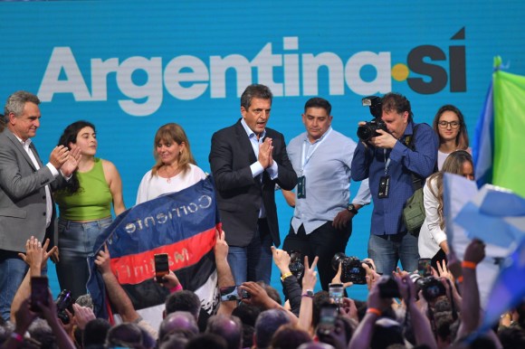 gruppo di persone su un palco, dietro di loro la scritta argentina sì