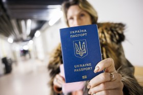 Una rifugiata in Svizzera mostra il suo passaporto ucraino.