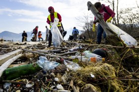 Menschen sammeln Plastik und Abfall vom Boden auf