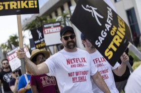 Attore in sciopero, la scritta sulla maglietta recita: Guardi Netflix e ti rilassi, grazie a me.